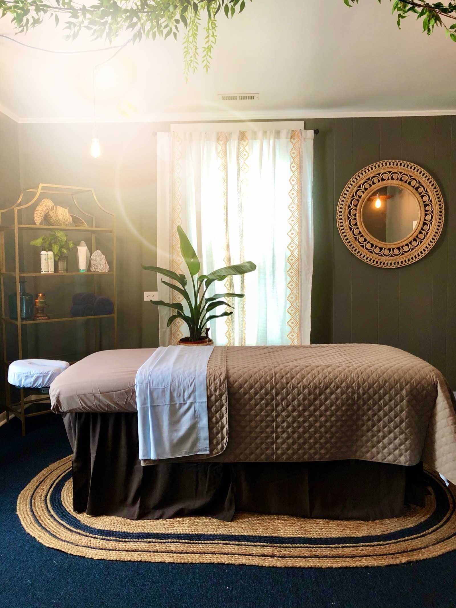 Hands of an Areté massage therapist mid-session in the warm-lit treatment room